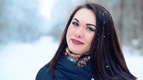 Close-up a Beautiful Young Girl Enjoys a Winter Walk in the Cold Snowy Forest