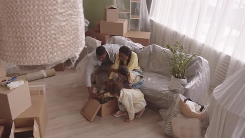 African American Family Unpacking Boxes in New Apartment