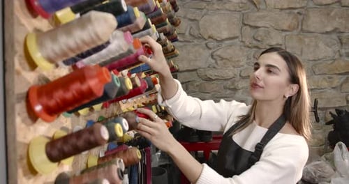 Woman Choosing Threads for Dressmaking in a Shop