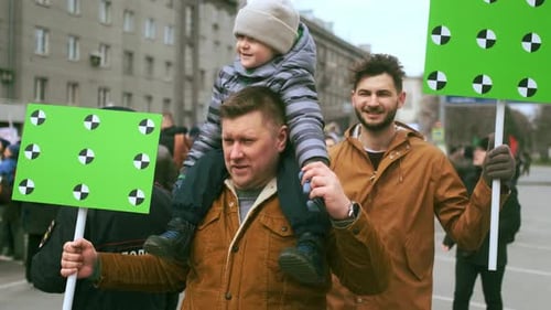 People Walking with Signs in an Urban Setting
