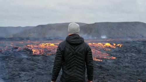 Man Watches Molten Lava Flow From Cooled Field