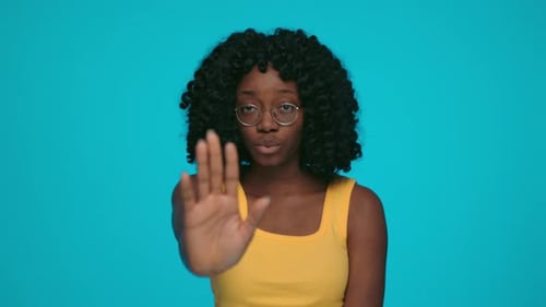 Ernste Afrikanerin zeigt Stoppschild mit Handfläche