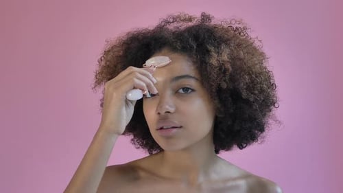 Young Woman Using Facial Roller in Beauty Routine