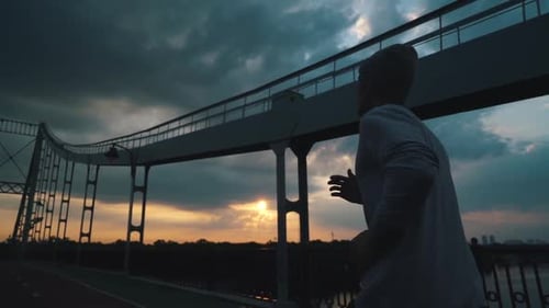 Guy Runs in the City at Sunrise