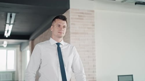 Confident Young Businessman Walking Through Modern Office