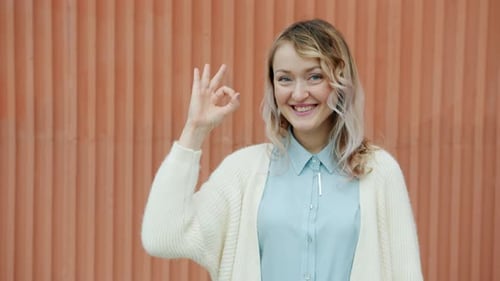 Woman Smiling and Making an Ok Sign