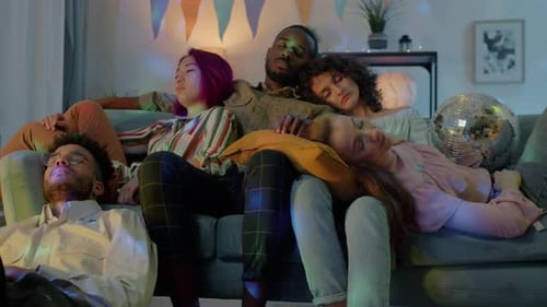 Exhausted Millennials Multiracial Group Sleeping After Party in Decorated Apartment at Night