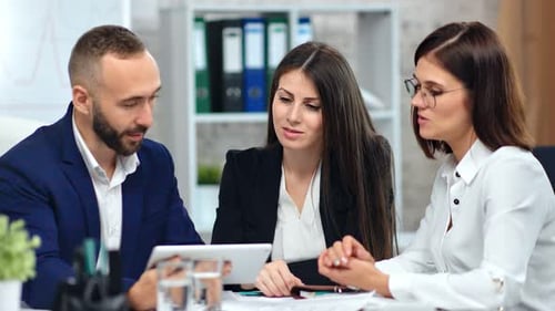 Colleagues Working Together Using Tablet in Office