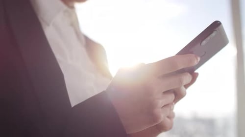 Hände einer Geschäftsfrau mit Handy