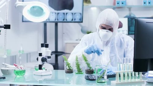 In High-end Modern Research Facility Scientist in Coverall Is Working on the Computer