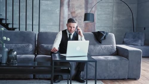 A Professional Sits in a Beautiful Dark Office in Front of a Laptop