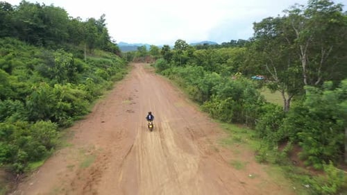 Woman Riding Motorbike On Country Road