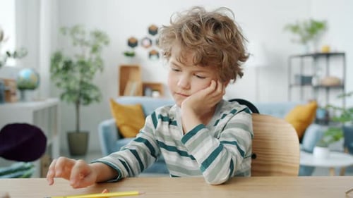 Slow Motion Portrait of Lonely and Bored Child Sitting Alone at Home