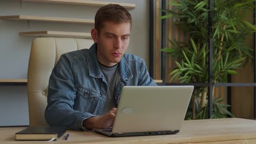 Excited Happy Man Looking at Laptop Computer Screen and Celebrating the Win Sitting in the Office