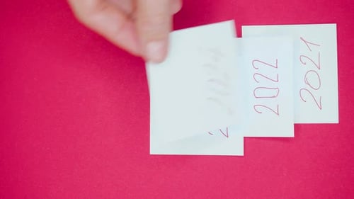 Vertical Video of a Male Hand is Pasting a Year 2024 Sticker Over the Year 2023