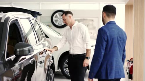 A Male Client Choosing Car at Dealership with the Help of Auto Seller Slow Motion