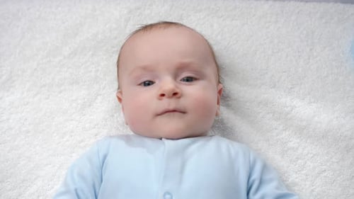 Peaceful Baby Lying on White Blanket