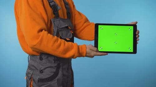 Construction Worker Holding Green Screen Tablet on the Side for Product Promoting