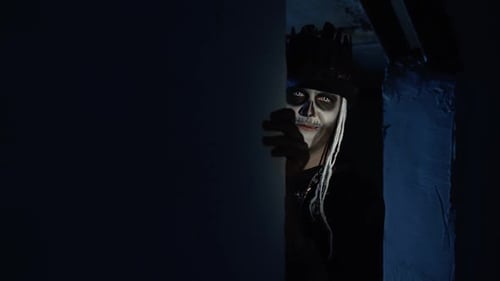 Creepy Man with Halloween Skeleton Makeup Slowly Appears From Dark Corner with Frightening Smile