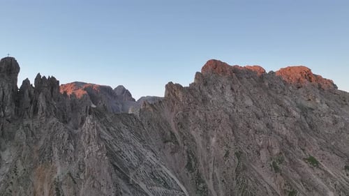 Dolomites mountains peaks with a hiking path on a summer sunrise