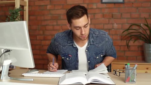 Front View of Focused Young Male College University Student Studying Preparing for Exam Taking