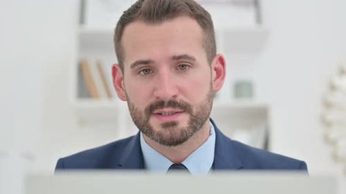 Bearded Man in Suit Talking on Video Call