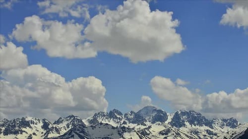 Snowy Mountains Under a Cloudy Blue Sky
