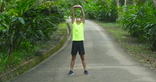 Man Stretching Before Workout in a Tropical Park