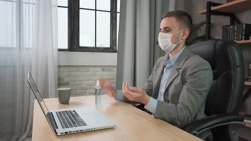Young Man Applying Sanitizer Spray Rubbing Hands Before Distance Computer Work From Home Office on