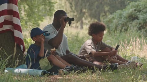 Dad with Two Sons Camping in Forest