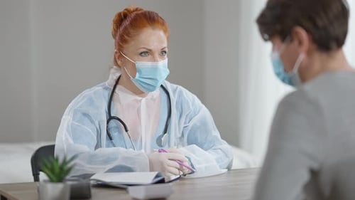 Female Doctor Consults with Patient in Office