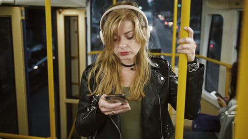 Woman Using Smartphone on Public Transportation at Night