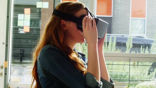 Woman Experiencing Virtual Reality With Headset in Office