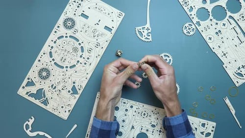 Homme assemblant de petits détails en bois en une seule pièce. Puzzle mécanique en bois