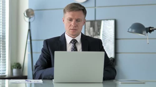 Man Working on Laptop in Corporate Office