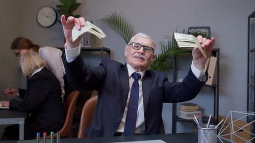 Successful Older Man Flashing Money in the Office