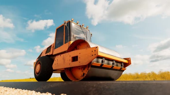 A big roller compacting asphalt on the road. Heavy machine going on hot ...