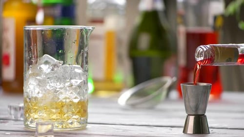 Une boisson rouge se verse dans un doseur