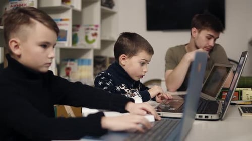 Children and Young Adult Working on Laptops Indoors