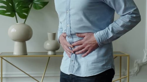 Adult Man With Upset Stomach Indoors