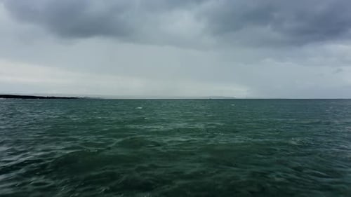 Drone Shot Low Over Ocean Surface Stormy Weather with a Downpour on the Horizon