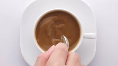 Top View Person Hand Stirring Coffee With Spoon