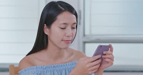 Woman Using Cell Phone Inside During the Day