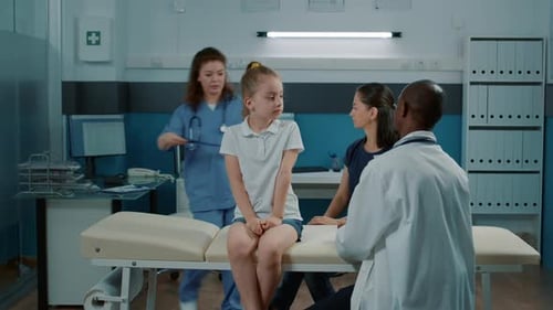 Doctor Discusses X-Ray with Child and Adult