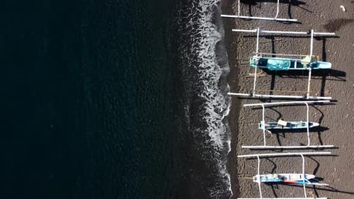 Top down view on boats on black sand beach
