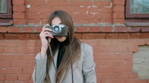 Fashionable Woman with Vintage Camera in Urban Setting