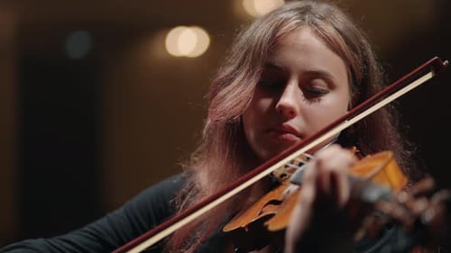 Pretty Young Woman is Playing Fiddle in Symphonic Orchestra on Scene of Music Hall Portrait