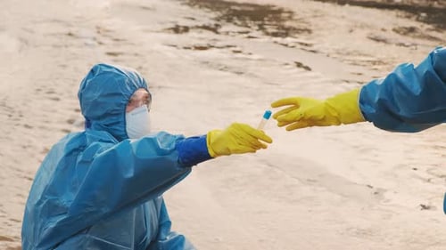Scientists Collecting Water Samples in Protective Gear