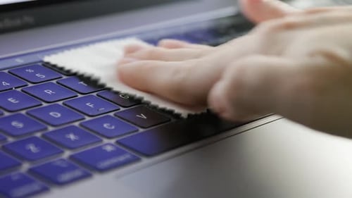 Hand Cleaning Laptop Keyboard with Cloth Close Up