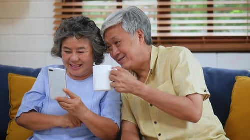 Senior Couple Using Smartphone and Drinking Coffee